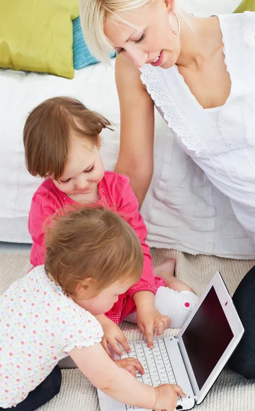 Ładny rodziny zabawy z laptopa w salonie — Zdjęcie stockowe