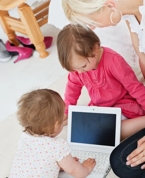 Famille rayonnante s'amuser avec un ordinateur portable dans le salon — Photo