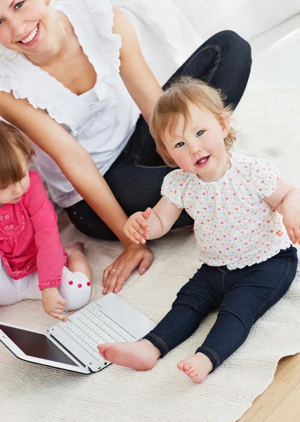 Piękne rodzinne zabawy z laptopa w salonie — Zdjęcie stockowe