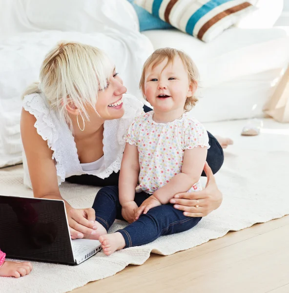 Famiglia sorridente che si diverte con un computer portatile nel soggiorno — Foto Stock