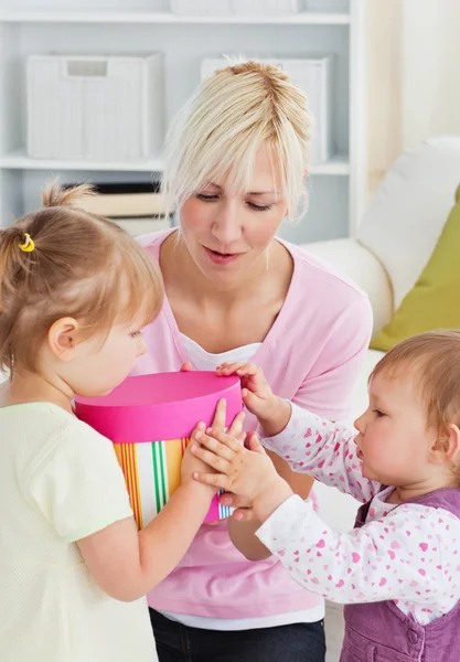 Smiling woman offering a gift to her girl in the living-room — Stock Photo, Image