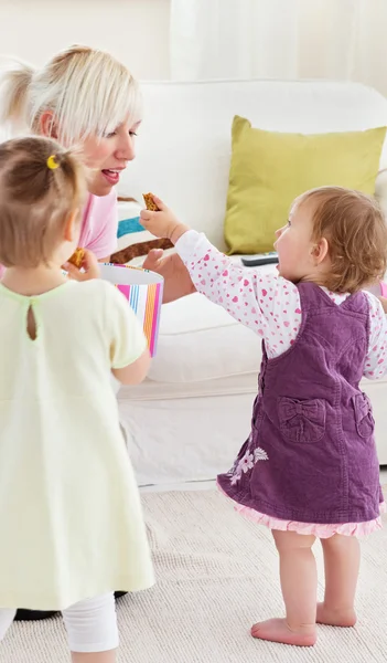 Smiling having fun with her girls in the living-room — Stock Photo, Image
