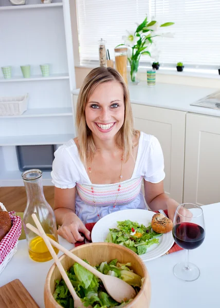Mujer linda comiendo una ensalada en la cocina — Foto de Stock