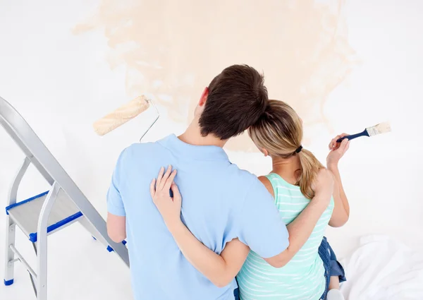 Νεαρό ζευγάρι ψάχνει σε έναν χρωματισμένο τοίχο — Φωτογραφία Αρχείου