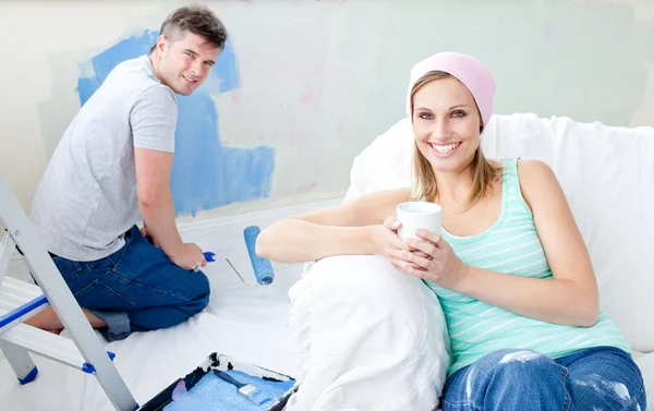 Bright woman relaxing boyfriend paint the room — Stock Photo, Image