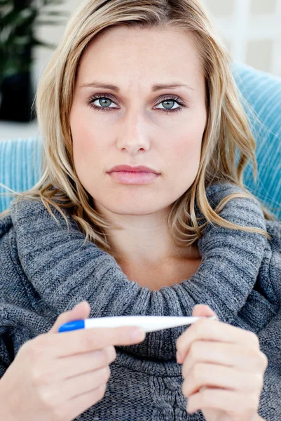 Young woman with a thermometer looking at the camera — Stock Photo, Image