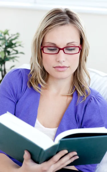 Молода жінка в окулярах читає книгу — стокове фото