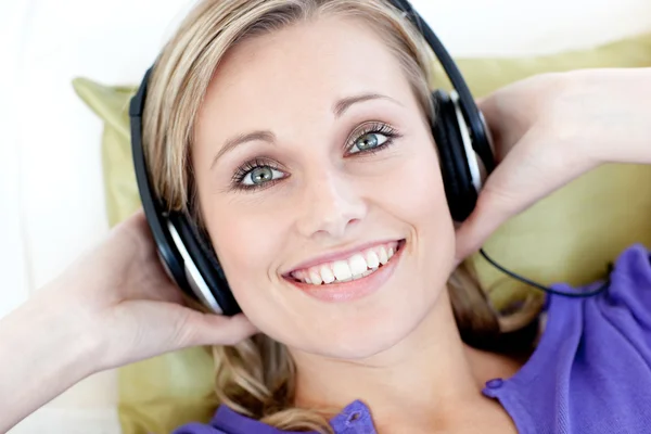 Retrato de una mujer sonriente escuchando música mirando a la cámara —  Fotos de Stock