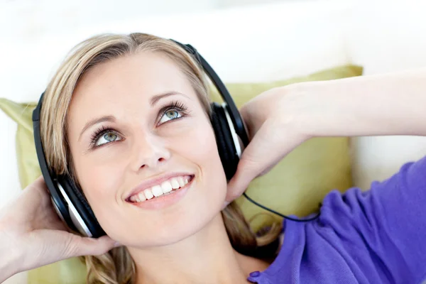 Donna gioiosa che ascolta musica in salotto — Foto Stock