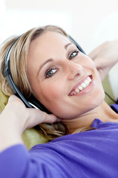 Bájos nő kanapé hallgat zenét fekve — Stock Fotó
