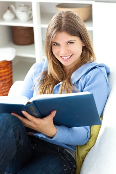Ευτυχισμένη γυναίκα διαβάζοντας ένα βιβλίο στο σαλόνι — Φωτογραφία Αρχείου