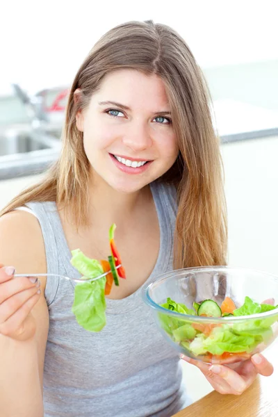 Smilling 女性が台所でサラダを食べる — ストック写真