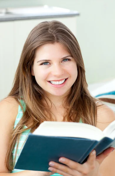 Glad kvinna läser en bok i vardagsrummet — Stockfoto