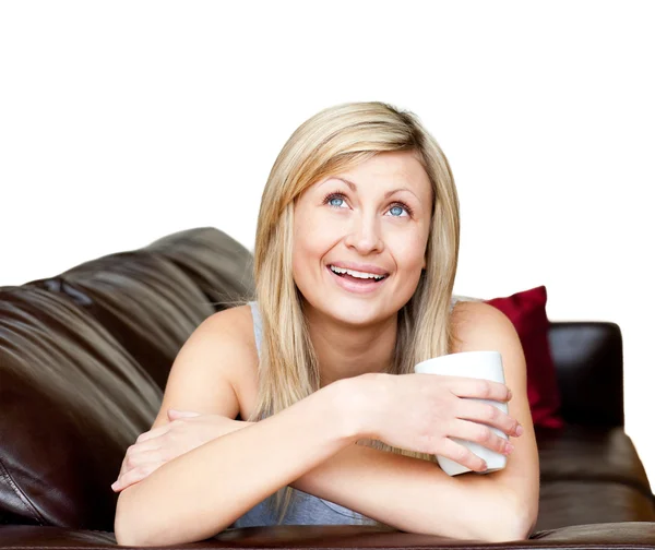 Donna ridente si trova su un divano marrone — Foto Stock