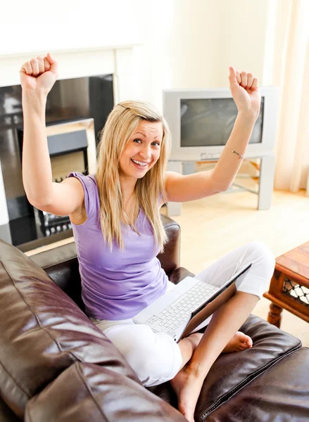 Cheering donna seduta sul divano e di lavoro — Foto Stock