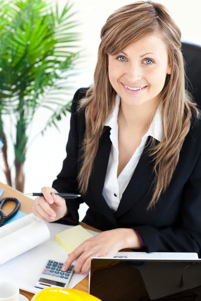 Mulher de negócios ferindo trabalhando em seu escritório com uma calculadora — Fotografia de Stock