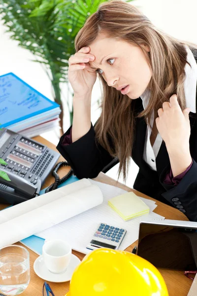 Empresária estressada sentada em seu escritório na frente da aba — Fotografia de Stock