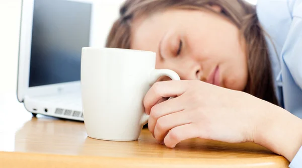 Slumbery kvinna som sover på tabell i office — Stockfoto