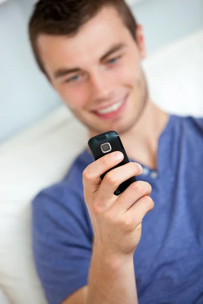 그의 휴대 전화에 문자 메시지를 작성 하는 아름 다운 남자 — 스톡 사진