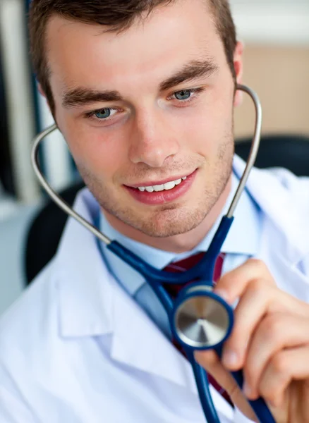 Affascinante giovane medico esaminando con uno stetoscopio — Foto Stock