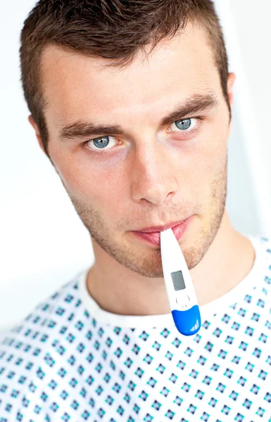 Ill man with a thermometer looking at the camera — Stock Photo, Image