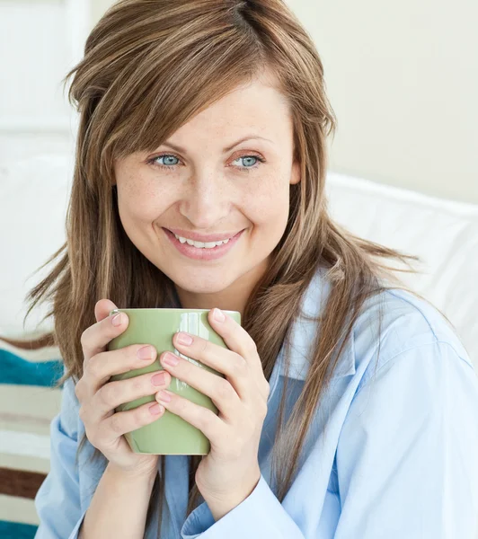 Beautiful woman holding a cup looking to the side — Stock Photo, Image