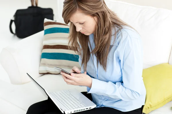 Ung affärskvinna med laptop och mobiltelefon — Stockfoto