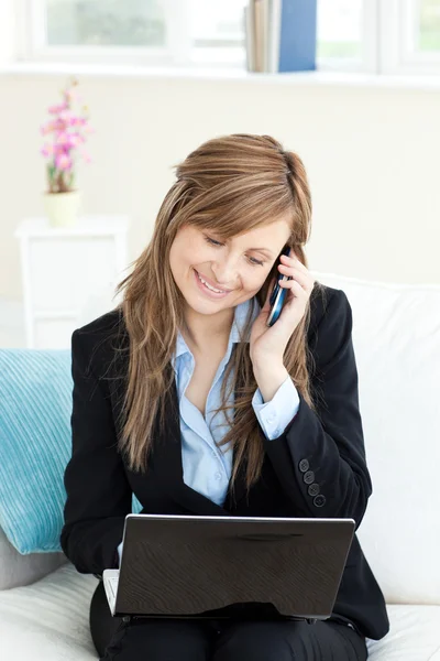 Donna d'affari incandescente utilizzando il suo telefono e laptop — Foto Stock