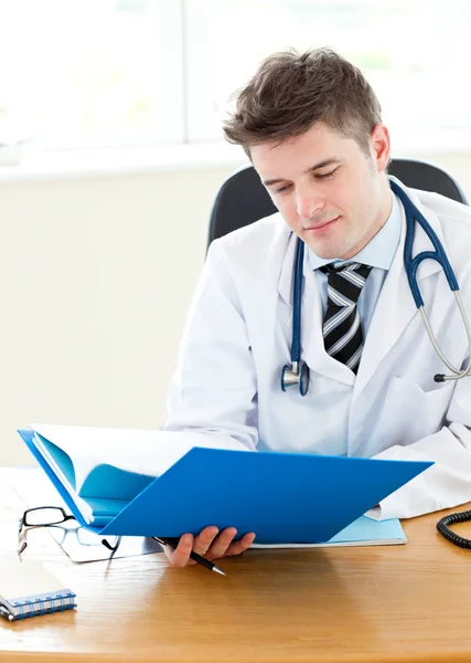 Knappe jonge dokter houden een map — Stockfoto