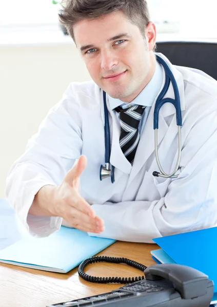 Sorridente medico tendendo la mano — Foto Stock
