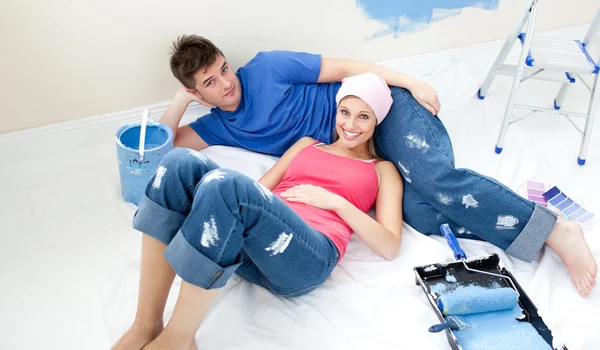 Giovane coppia rilassante dopo aver dipinto una stanza — Foto Stock