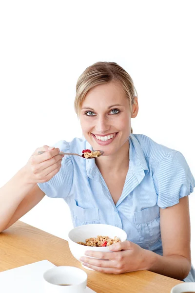 Delilghted kobieta jedzenie zbóż siedzi przy stole — Zdjęcie stockowe