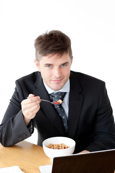 Biznesmen czarujący za pomocą laptopa, jedząc śniadanie — Zdjęcie stockowe