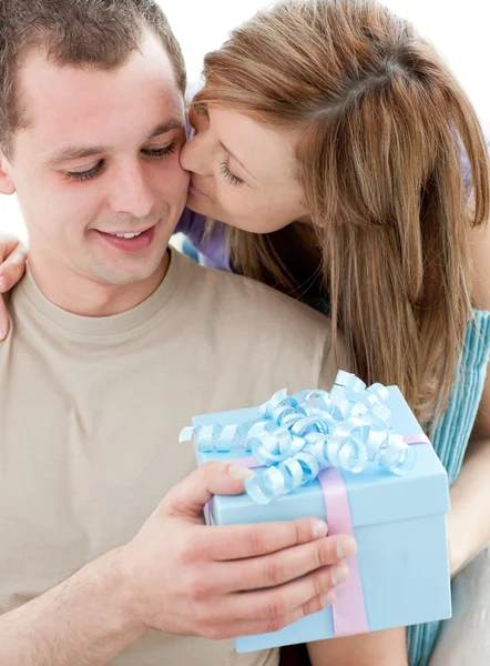 Beautiful girlfriend giving a present and a kiss to his handsome — Stock Photo, Image