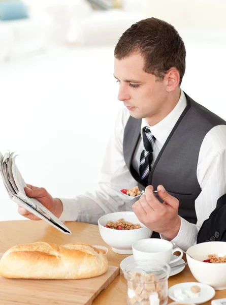 Businessman eating cereals while reading the news — Stock Photo, Image