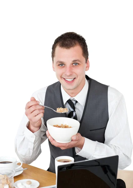 Усміхнений бізнесмен їсть зернові, дивлячись на камеру — стокове фото
