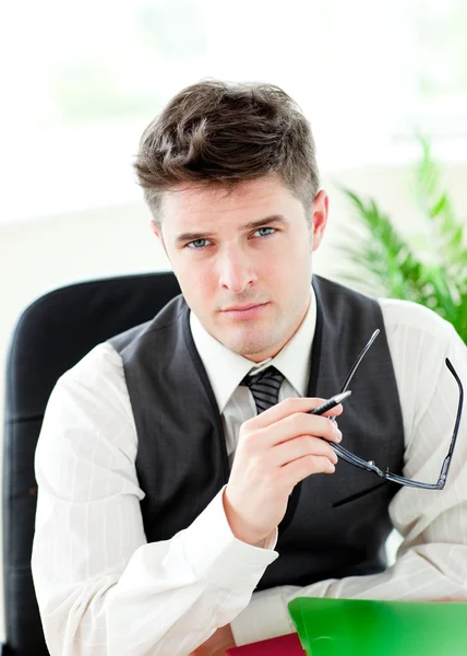 Portait of a self-assured businessman holding glasses — Stock Photo, Image