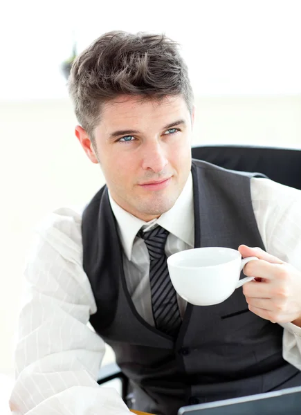 Впевнений молодий бізнесмен з ноутбуком, що тримає каву — стокове фото