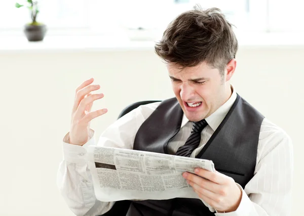 Retrato de um empresário irritado lendo um jornal — Fotografia de Stock