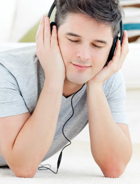 Позитивный молодой человек слушает музыку с закрытыми глазами — стоковое фото