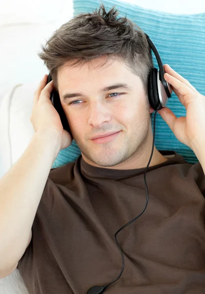 Pohledný muž se sluchátky poslechu hudby — Stock fotografie