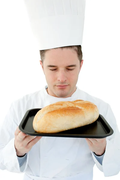 Um cozinheiro masculino com olhos fechados cheira a pão — Fotografia de Stock
