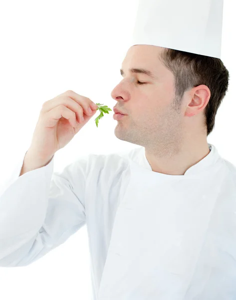 Jovem cozinheiro encantador com olhos fechados segurando uma erva — Fotografia de Stock