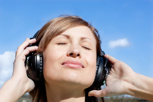 Piękna kobieta listenng muzyka na zewnątrz — Zdjęcie stockowe