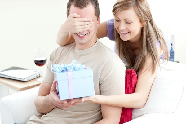 Улыбающаяся женщина дарит подарок своему парню — стоковое фото