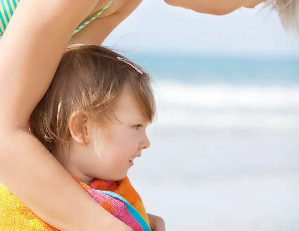 Ett tröstlöst flicka i en handduk på stranden — Stockfoto