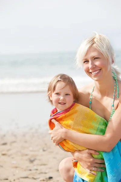 Wesoła dziewczyna i jej matka uśmiechający się na plaży — Zdjęcie stockowe