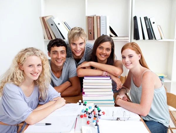 Adolescentes sorridentes estudando Ciência em uma biblioteca — Fotografia de Stock