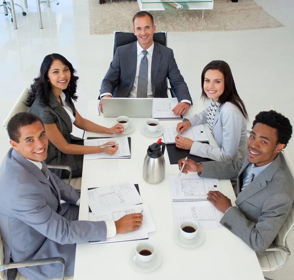Business in einem Meeting, das in die Kamera lächelt — Stockfoto