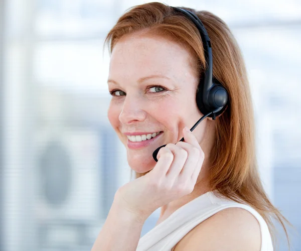 Lachende verkoop vertegenwoordiger vrouw met een headset — Stockfoto